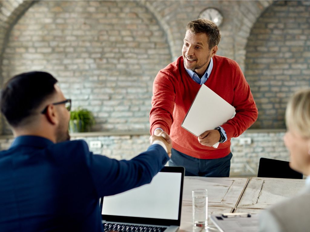 Fotografia di un uomo che stringe la mano a un altro uomo durante un&#39;intervista
